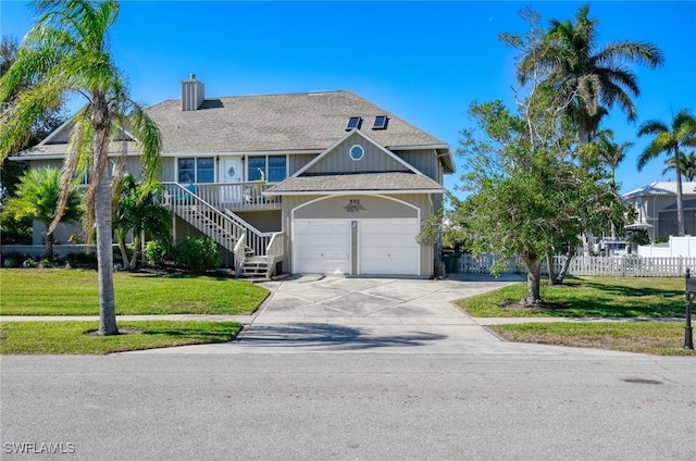 view of front of house with a garage, covered porch, and a front yard