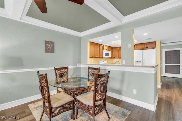 dining area with ceiling fan, ornamental molding, and dark wood-type flooring