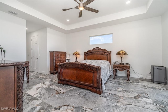 bedroom with a tray ceiling and ceiling fan