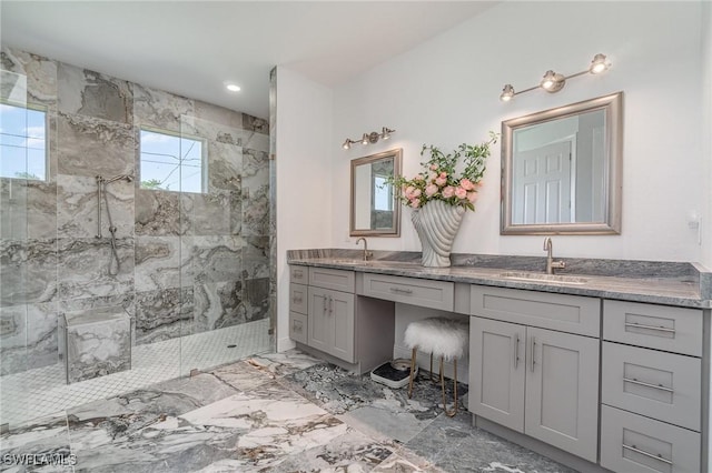 bathroom with vanity, a healthy amount of sunlight, and tiled shower