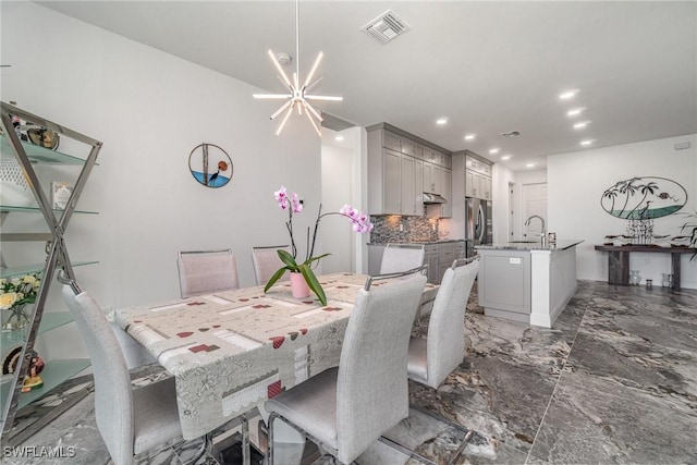 dining room featuring sink and an inviting chandelier