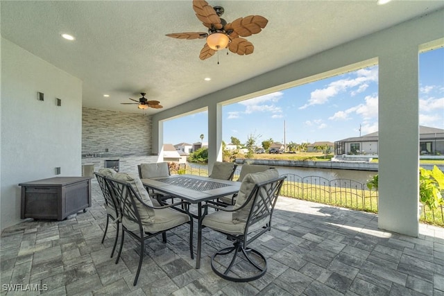 view of patio / terrace featuring ceiling fan and a water view