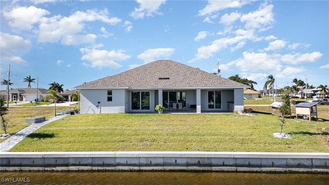 rear view of property featuring a yard, a water view, and a patio