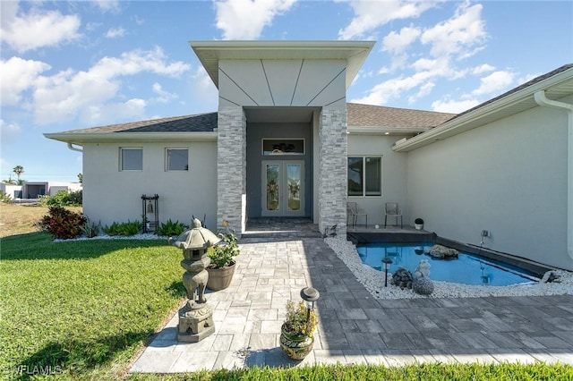 rear view of house featuring a yard and french doors