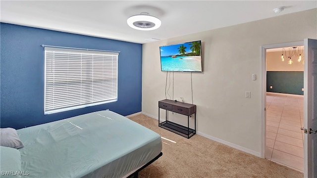 bedroom with light colored carpet and an inviting chandelier