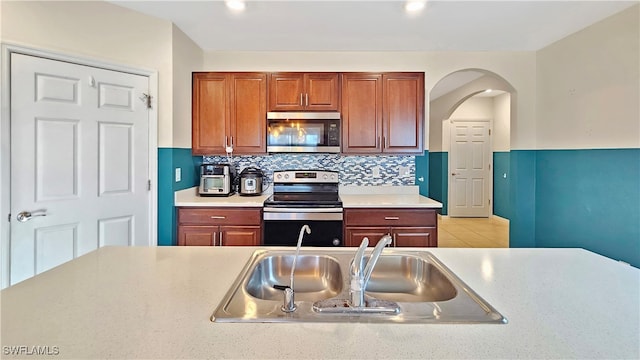 kitchen featuring appliances with stainless steel finishes, backsplash, and sink