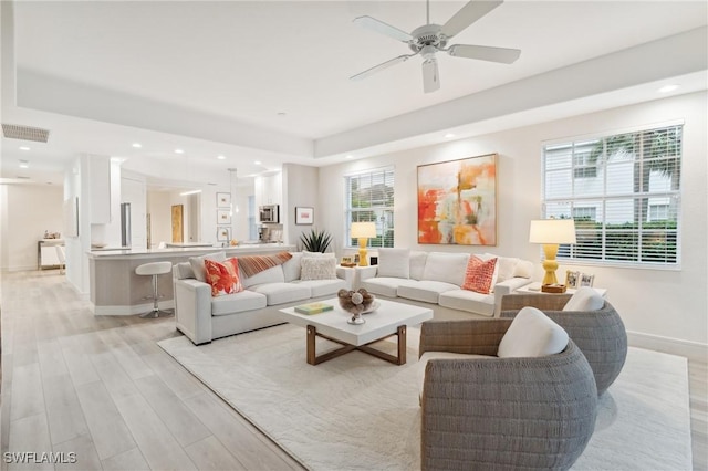 living room featuring plenty of natural light, light hardwood / wood-style floors, and ceiling fan