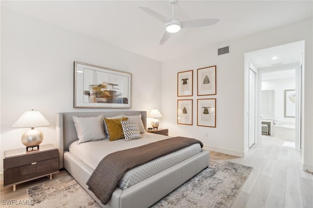 bedroom featuring ceiling fan, light wood-type flooring, and ensuite bath