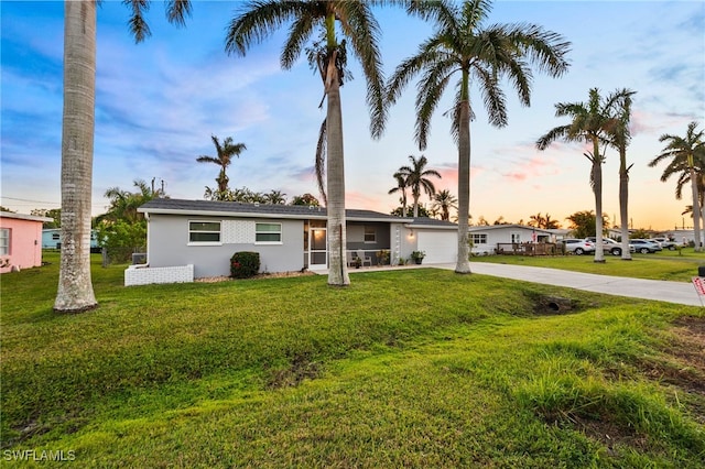 ranch-style house featuring a lawn and a garage