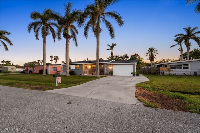 ranch-style home with a yard and a garage