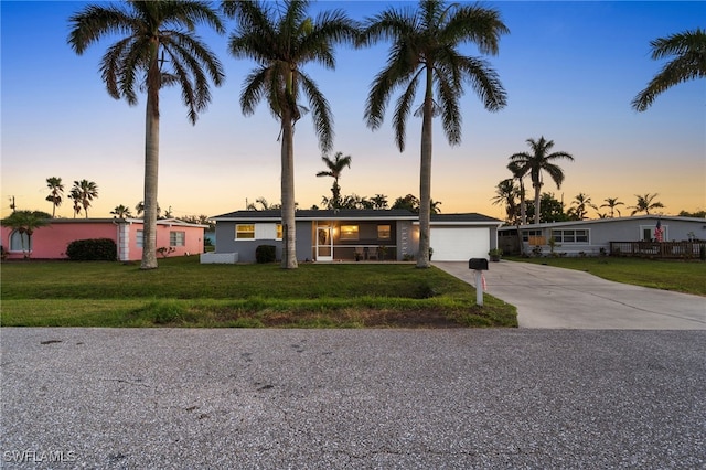 single story home featuring a yard and a garage