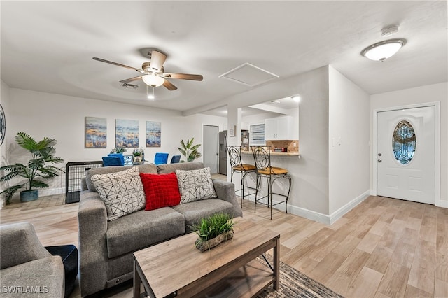 living room featuring ceiling fan and light hardwood / wood-style flooring