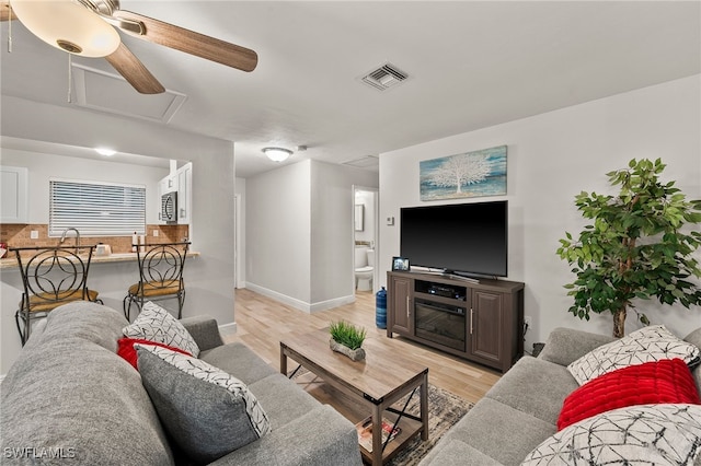 living room featuring ceiling fan and light hardwood / wood-style floors