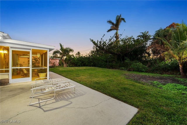 yard at dusk with a patio area