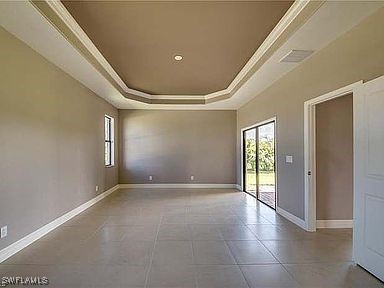 empty room featuring a raised ceiling and crown molding