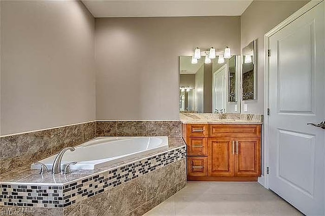 bathroom with vanity, tiled bath, and tile patterned floors