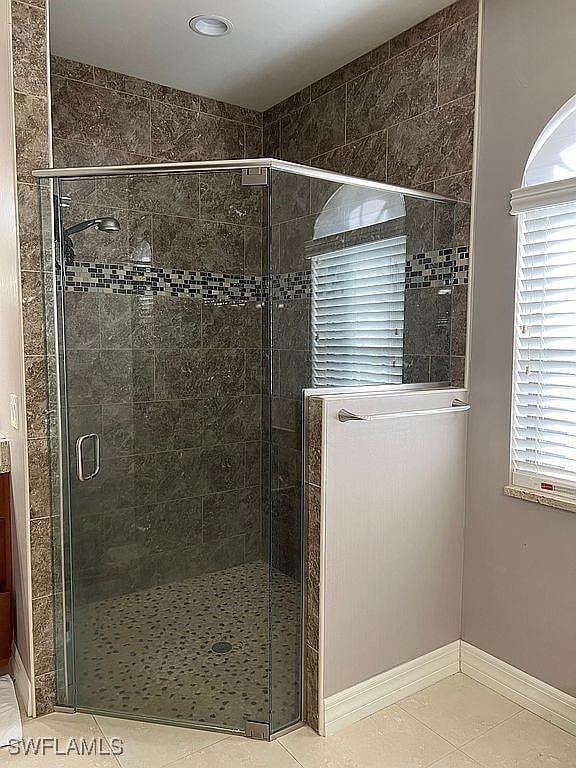 bathroom with tile patterned floors and walk in shower