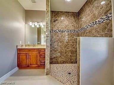 bathroom featuring vanity and a tile shower