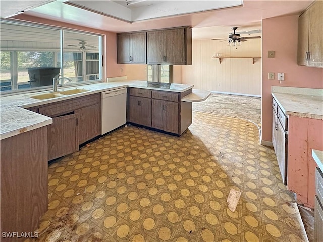 kitchen with white dishwasher, a raised ceiling, kitchen peninsula, and sink