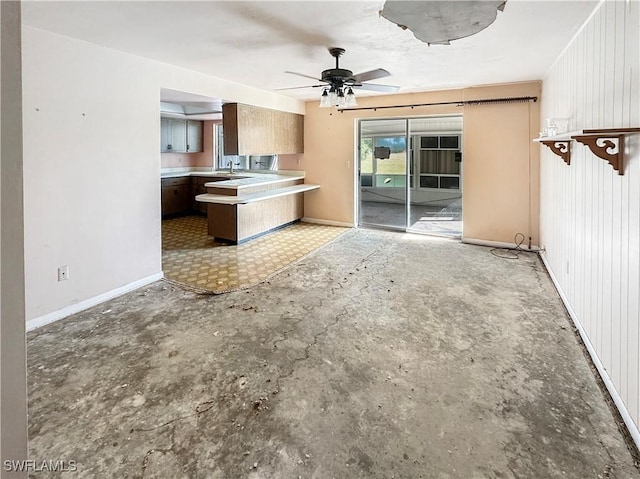 unfurnished living room with ceiling fan and sink