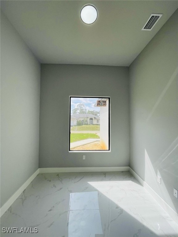 spare room featuring marble finish floor, visible vents, and baseboards