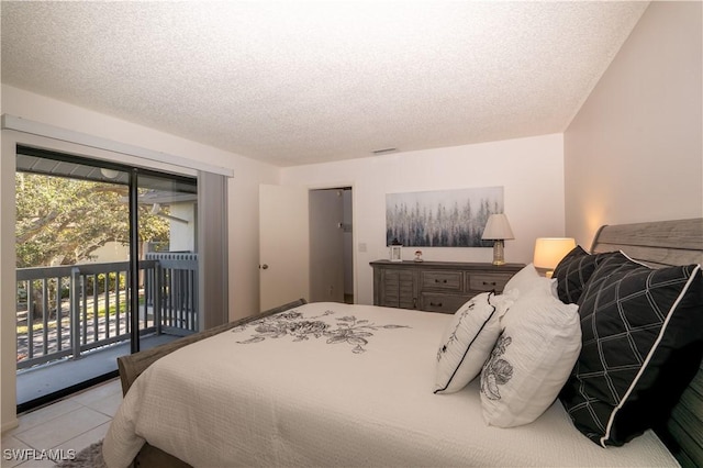 bedroom with access to outside, light tile patterned floors, and a textured ceiling