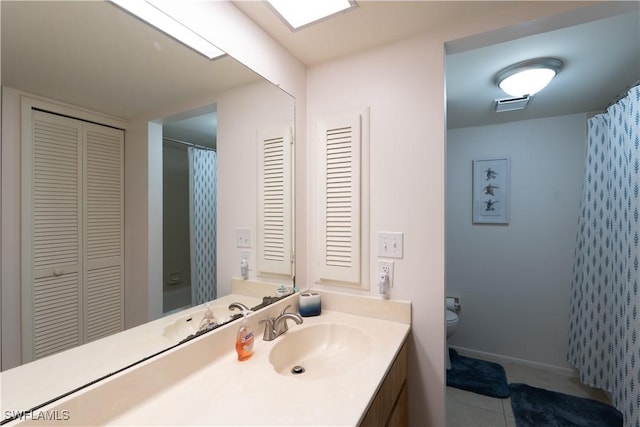 bathroom with tile patterned flooring, vanity, curtained shower, and toilet