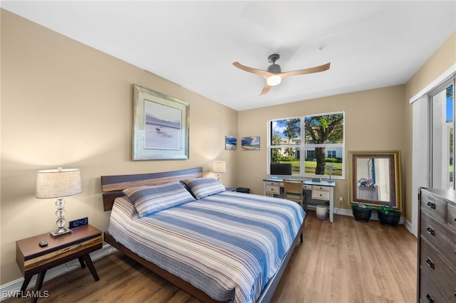 bedroom with ceiling fan, baseboards, and wood finished floors