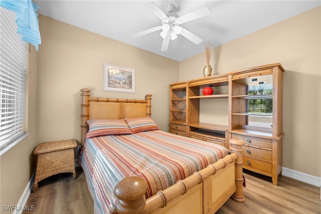 bedroom with baseboards, light wood-type flooring, and ceiling fan