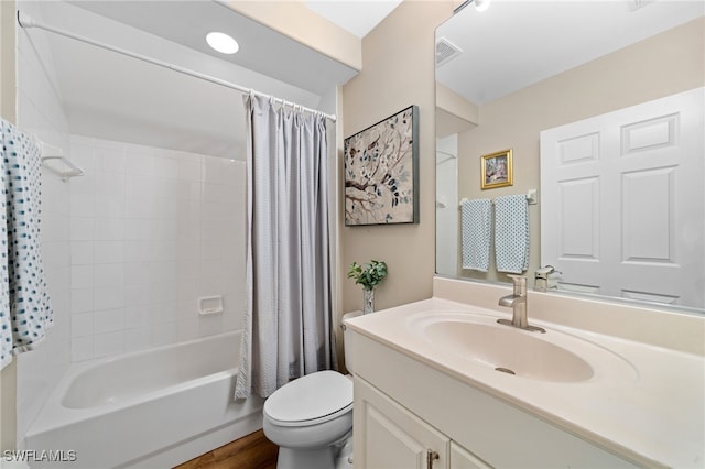 bathroom with visible vents, toilet, wood finished floors, shower / tub combo with curtain, and vanity