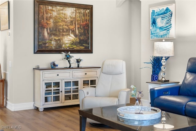 living area featuring baseboards and wood finished floors