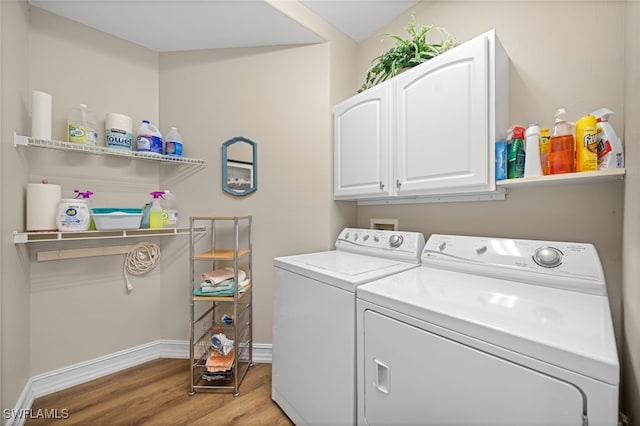 laundry room featuring light wood-style floors, washer and dryer, cabinet space, and baseboards