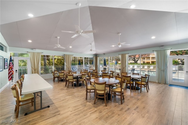 dining space featuring vaulted ceiling, light wood-type flooring, and a wealth of natural light