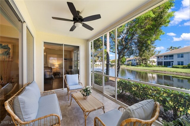 sunroom with a water view and ceiling fan