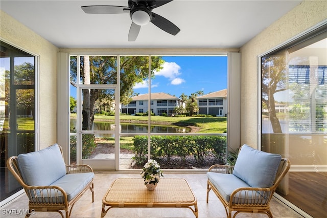 sunroom featuring a wealth of natural light, a water view, and ceiling fan