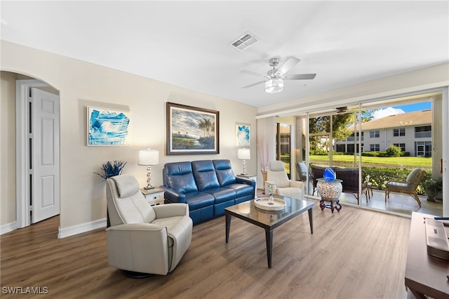 living room with visible vents, a ceiling fan, wood finished floors, arched walkways, and baseboards