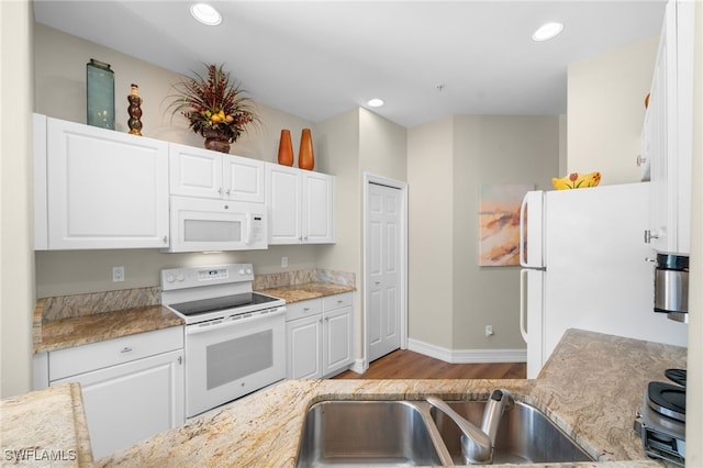 kitchen with white appliances, light wood-style flooring, recessed lighting, a sink, and white cabinets