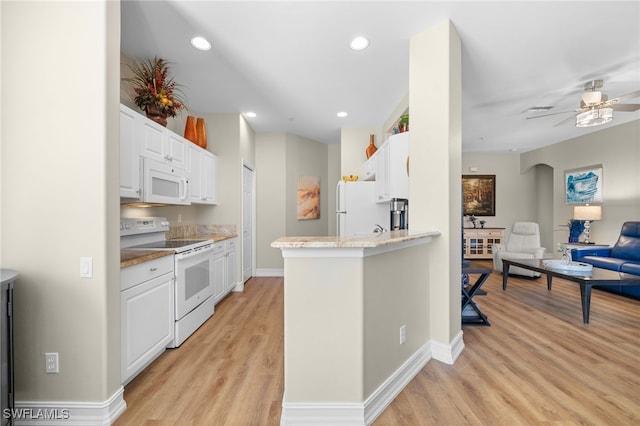 kitchen featuring light wood finished floors, open floor plan, recessed lighting, white cabinets, and white appliances