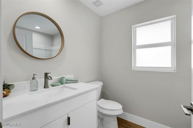 bathroom with vanity, hardwood / wood-style flooring, and toilet