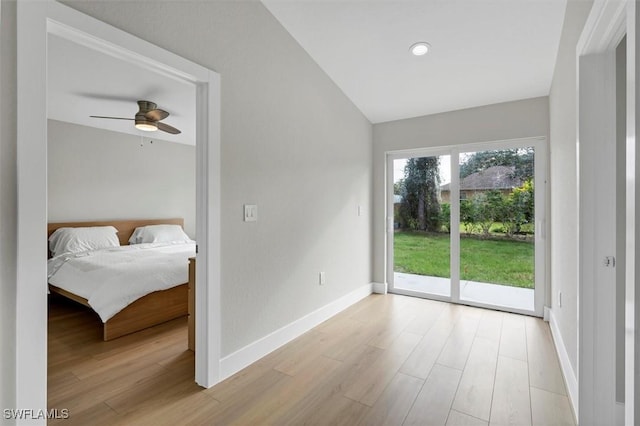 interior space with ceiling fan, light wood-type flooring, access to outside, and vaulted ceiling