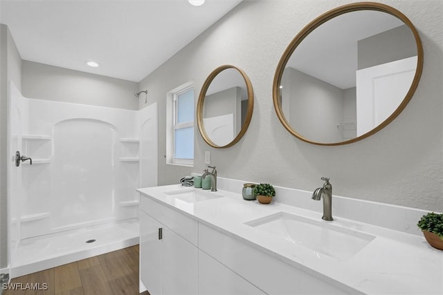 bathroom with a shower, vanity, and hardwood / wood-style flooring