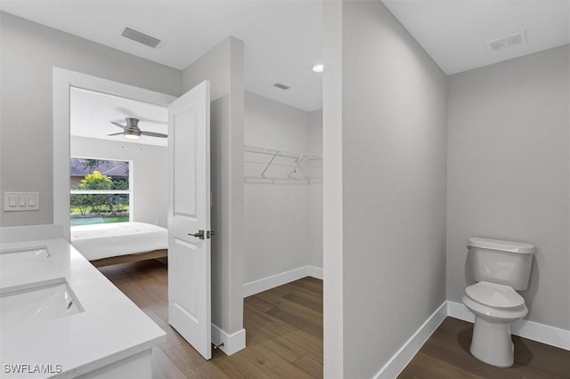 bathroom with vanity, hardwood / wood-style flooring, toilet, and ceiling fan