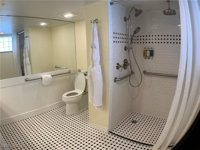 bathroom featuring tile patterned flooring, a shower with shower curtain, and toilet