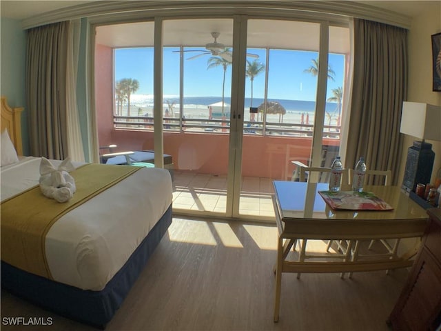 bedroom featuring a water view and light wood-type flooring