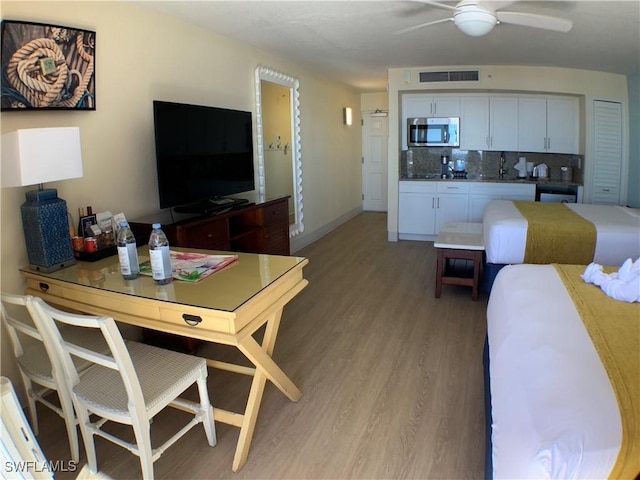 living room with ceiling fan and light hardwood / wood-style flooring