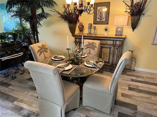 dining area with hardwood / wood-style flooring and a notable chandelier