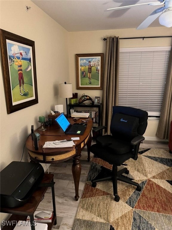 home office with ceiling fan and light hardwood / wood-style floors