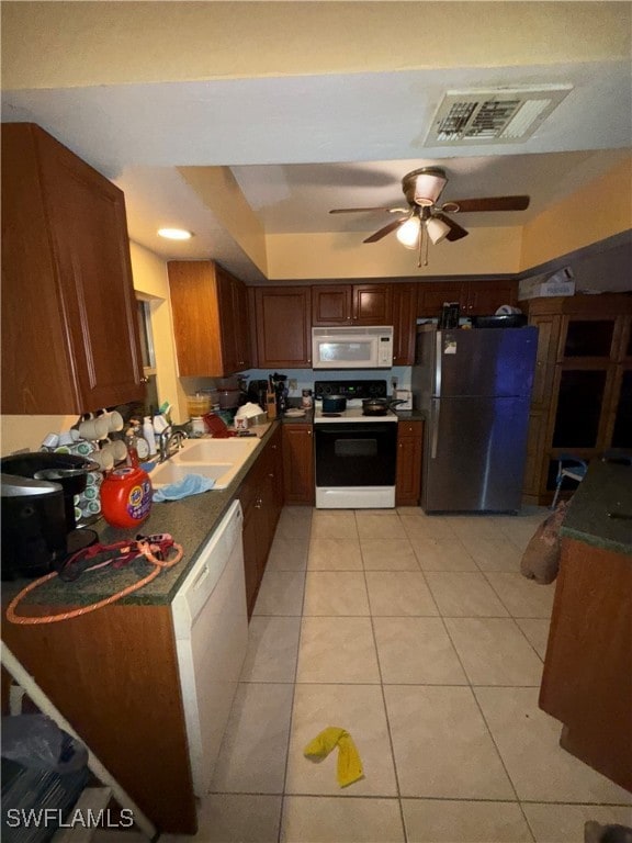 kitchen featuring light tile patterned floors, white appliances, ceiling fan, and sink