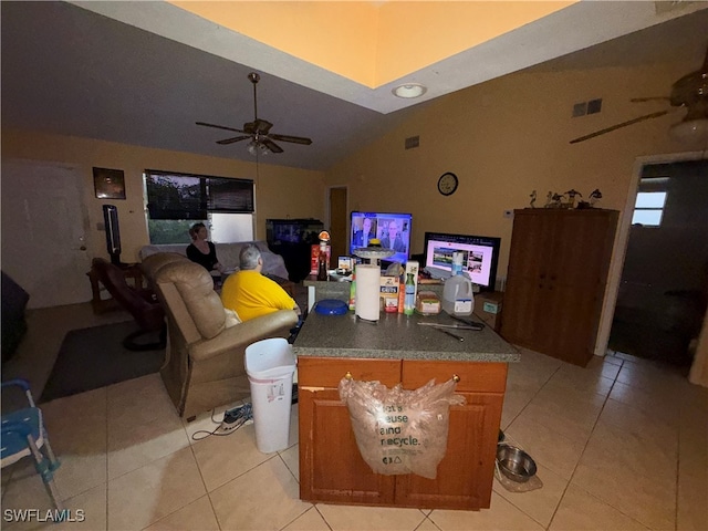 living room featuring lofted ceiling, ceiling fan, and light tile patterned floors