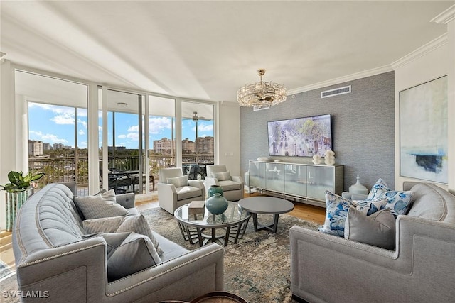 living room featuring expansive windows, an inviting chandelier, ornamental molding, and hardwood / wood-style flooring